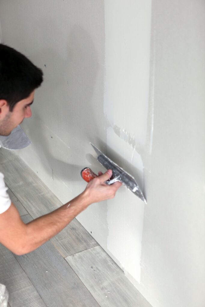 young artisan plastering wall